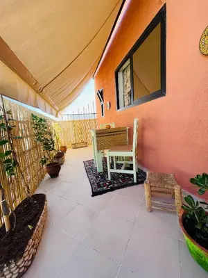 a patio with a table and chairs on a pink wall at Pleasant Studio In Casablanca in Casablanca