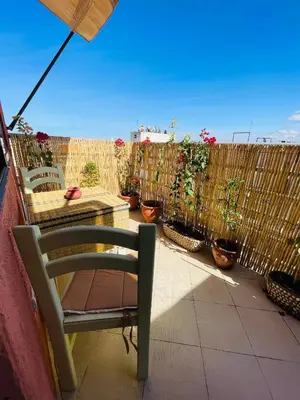 a patio with a chair and a fence with potted plants at Beautiful Studio in the heart of Casablanca in Casablanca