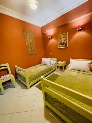 two beds in a room with orange walls at Beautiful Studio in the heart of Casablanca in Casablanca