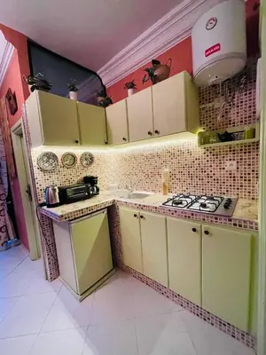 a small kitchen with yellow cabinets and a stove at Beautiful Studio in the heart of Casablanca in Casablanca