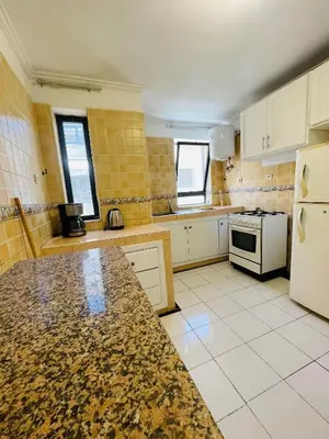 a kitchen with white appliances and yellow tiles at Charming Getaway in Casablanca Maroc, Cozy Home with Thoughtful Amenities in Casablanca