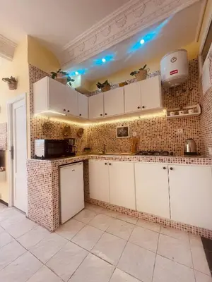 a kitchen with white cabinets and blue lights on the wall at Charming Studio In Casablanca in Casablanca