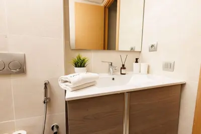 a bathroom with a sink and a mirror at Stylish 1BR flat in Hay Riad Central Rabat in Rabat