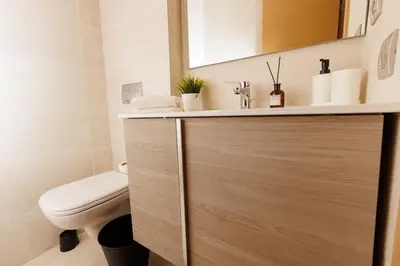 a bathroom with a toilet and a sink and a vanity at Stylish 1BR flat in Hay Riad Central Rabat in Rabat