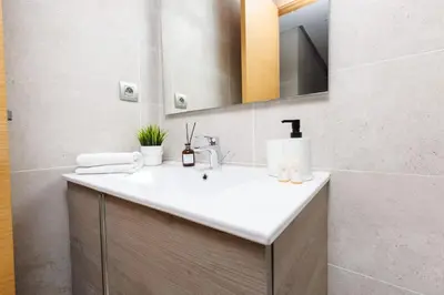 a bathroom with a white sink and a mirror at Stylish 1BR flat in Hay Riad Central Rabat in Rabat