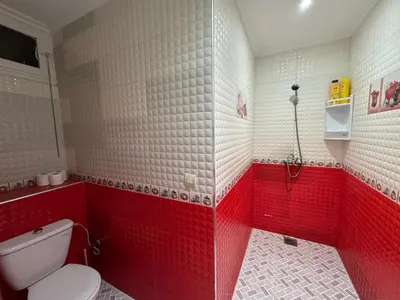 a red and white bathroom with a toilet and a shower at Casablanca Central Suites - Casa Port in Casablanca