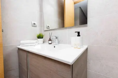 a bathroom with a white sink and a mirror at Central Charm: 1-Bed Apartment in Hay Riad in Rabat