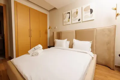 a bedroom with a large white bed with white pillows at Central Charm: 1-Bed Apartment in Hay Riad in Rabat