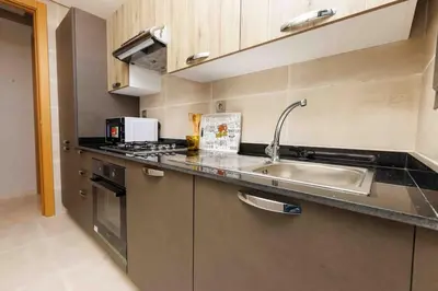 a kitchen with a sink and a counter top at Central Charm: 1-Bed Apartment in Hay Riad in Rabat