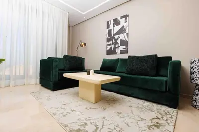 a living room with a green couch and a coffee table at Central Charm: 1-Bed Apartment in Hay Riad in Rabat