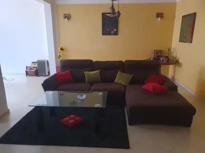a living room with a brown couch and a glass table at Appartement spacieux, exceptionnel in Temara