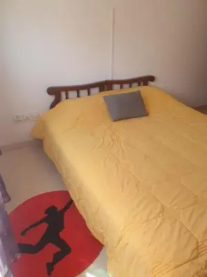a bedroom with a bed with a woman on a rug at Appartement spacieux, exceptionnel in Temara