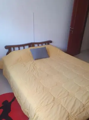 a bed with a blue pillow on top of it at Appartement spacieux, exceptionnel in Temara
