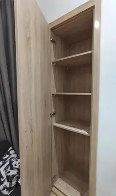 a wooden cupboard with empty shelves in a room at Lovely Studio in the city centre with WIFI. in Casablanca