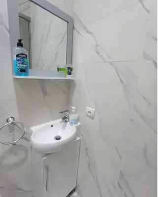 a white bathroom with a sink and a mirror at Lovely Studio in the city centre with WIFI. in Casablanca