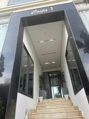 a modern house with glass doors and stairs at Belle appartement tout neuf in Bouznika
