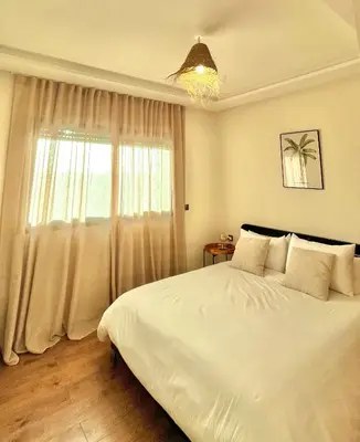 a bedroom with a white bed and a window at Cozy 2 bedrooms flat at Dar Bouazza in Dar Bouazza