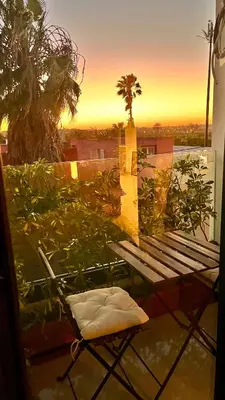 a bench on a balcony with a sunset in the background at Cozy 2 bedrooms flat at Dar Bouazza in Dar Bouazza
