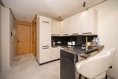 a kitchen with a black counter and white cabinets at Studio chic avec parking in Casablanca