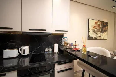 a kitchen with black counter tops and white cabinets at Studio chic avec parking in Casablanca