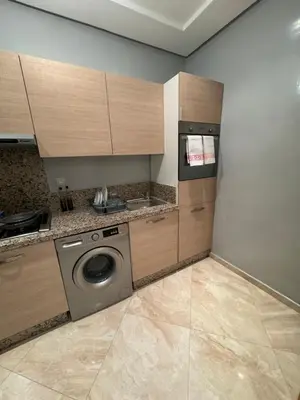 a kitchen with a washing machine and a dishwasher at Bouznika Beach appartement de luxe avec piscine in Bouznika