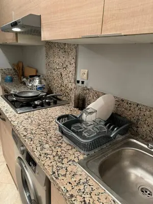 a kitchen counter with a sink and a stove at Bouznika Beach appartement de luxe avec piscine in Bouznika
