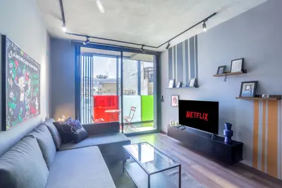 a living room with a couch and a tv at Résidence Galilée - Gauthier in Casablanca