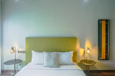 a bedroom with a white bed with two lamps at Résidence Galilée - Gauthier in Casablanca