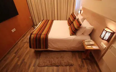 a small bedroom with a bed and a telephone at Casablanca Suites & Spa in Casablanca