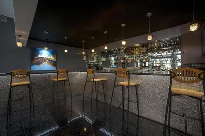 a bar with wooden stools and a bar counter at Casablanca Suites & Spa in Casablanca
