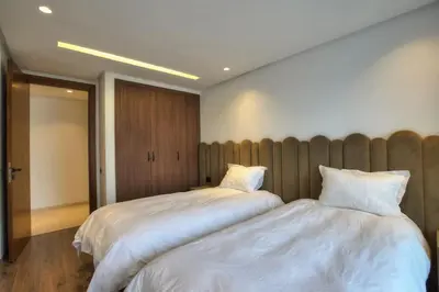a bedroom with two beds with white sheets at Appart en face de la tour CFC in Casablanca