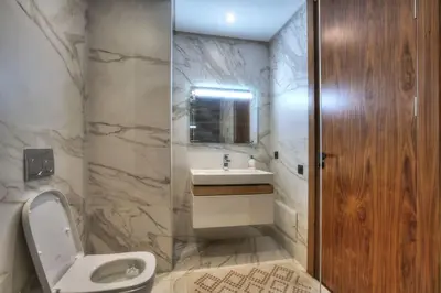 a bathroom with a white toilet and a sink at Appart en face de la tour CFC in Casablanca