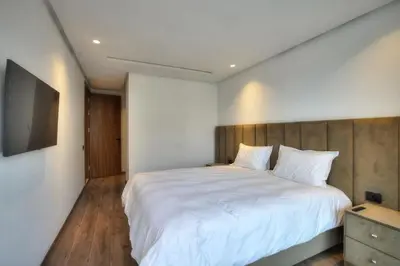 a bedroom with a white bed and a television at Appart en face de la tour CFC in Casablanca