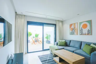 a living room with a blue couch and a table at Serenity in Casablanca