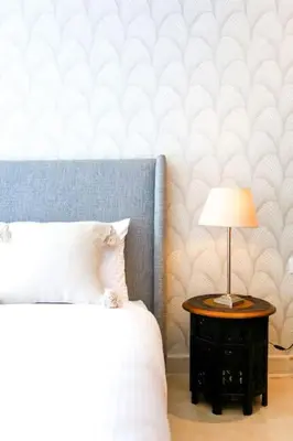 a bedroom with a bed and a table with a lamp at Waterloo in Casablanca