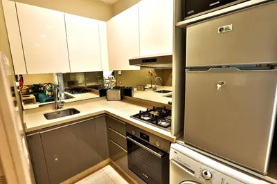 a kitchen with white cabinets and a stainless steel refrigerator at Anfa Flores in Casablanca