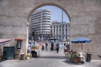 a group of people walking down a street under an arch at Appartement Panoramique in Casablanca