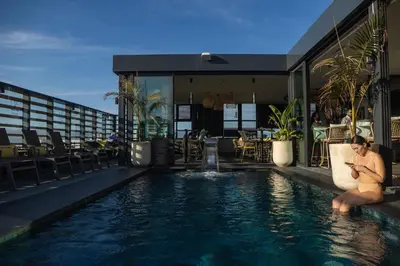 a man sitting on a chair next to a swimming pool at Courtyard by Marriott Casablanca Downtown in Casablanca