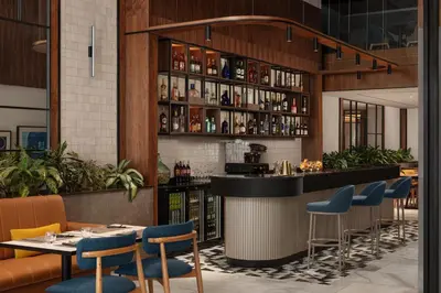 a bar in a restaurant with blue chairs and tables at Courtyard by Marriott Casablanca Downtown in Casablanca