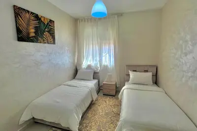 a bedroom with two beds and a blue light at T6 Appartement entièrement neuf au cœur de Témara in Temara