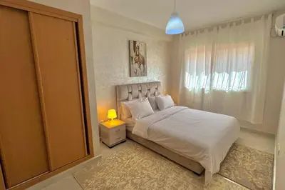 a bedroom with a white bed and a window at T6 Appartement entièrement neuf au cœur de Témara in Temara