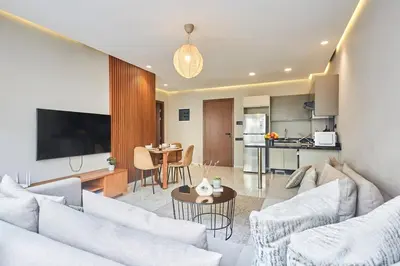 a living room with two couches and a kitchen at Chic and Cozy 1 Bedroom Oasis in the Heart of Casa in Casablanca