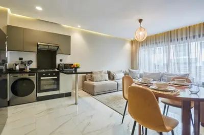 a kitchen and living room with a table and a couch at Chic and Cozy 1 Bedroom Oasis in the Heart of Casa in Casablanca