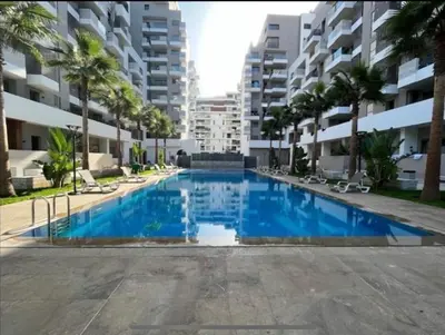 a large blue swimming pool in front of a building at prestigieuse à casa finance city in Casablanca