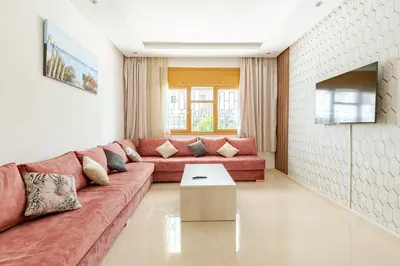 a living room with a red couch and a table at New Luxurious apartment Agdal Rabat center in Rabat