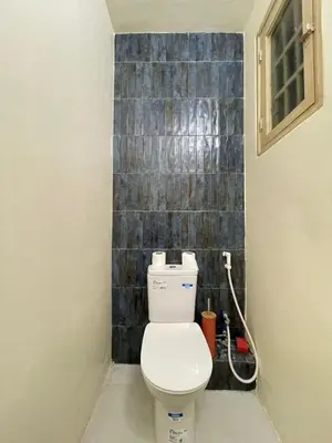 a bathroom with a toilet and a tile wall at Appartement Cosy Agdal Centre Rabat in Rabat