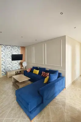 a living room with a blue couch and a table at Appartement Cosy Agdal Centre Rabat in Rabat