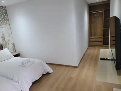 a bedroom with a white bed and a wooden floor at Eden Room SCH in Rabat