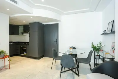 a dining room with a table and chairs and a kitchen at Résidence Windsor in Casablanca