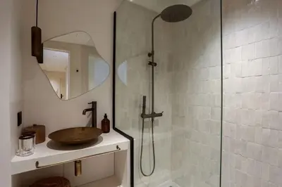 a bathroom with a shower with a sink and a glass shower stall at Résidence La Fontaine - Racine in Casablanca